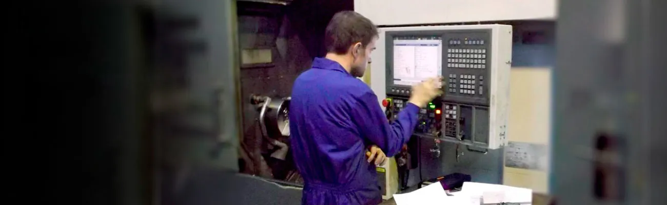 INAMESA operator programming a CNC control while machining a part